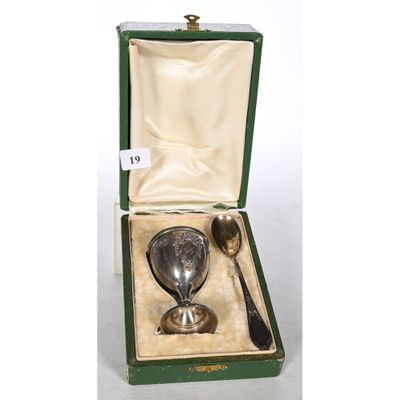 an antique silver spoon and spoon rest in a green case