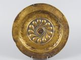 une image représentant une assiette en or ornée d'un motif floral