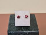 a pair of ruby earrings sitting on top of a marble block