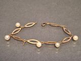 a close up of a bracelet with pearls on it