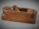 an old wooden plane sitting on top of a gray surface