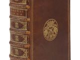 un vieux livre marron avec des bordures dorées sur la couverture