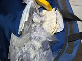 a blue bag filled with plastic bags sitting on the floor