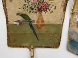 two fan shaped pictures of birds and flowers on the wall