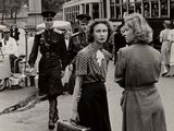 une photo en noir et blanc d'une femme et d'un homme marchant dans la rue