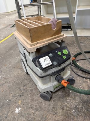 une machine posée au sol, sur laquelle se trouve une boîte