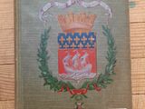un gros plan sur un livre posé sur une table en bois, avec un blason