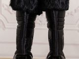 black fur lined boots on a wooden table with a white wall in the background