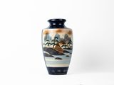 un vase avec un tableau posé sur une table