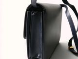 an image of a black purse on a white surface