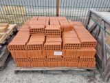 a pile of bricks sitting on a pallet in front of a fence