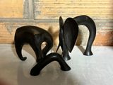 deux statues d'éléphants noirs posées sur une surface blanche