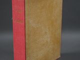 an old book sitting on top of a table on a gray surface