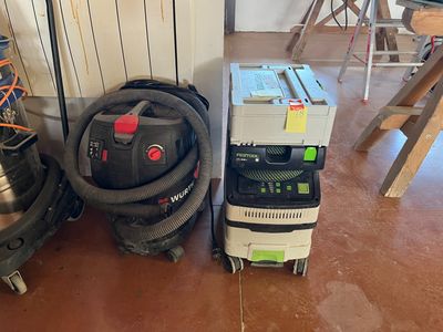 un aspirateur et un aspirateur posé par terre dans une pièce