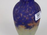 a purple vase with a tag on it sitting on a table