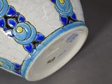a white vase with a blue and yellow design on it