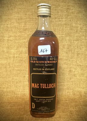 une vieille bouteille de Mac Tulloch posée sur une table