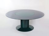 une table ronde en verre avec un piètement noir et un plateau circulaire en verre