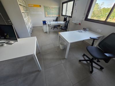 a room with a desk, chair, and computer monitor in it