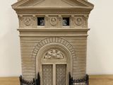 a small model of a building on a wooden table