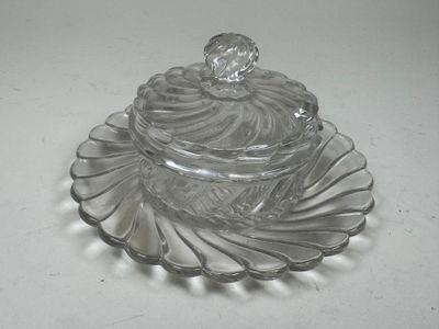 a clear glass container with a lid on a plate