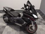 a black motorcycle parked in a room with a checkered floor