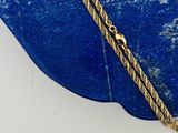 une photo d'un collier plaqué or sur une pierre bleue
