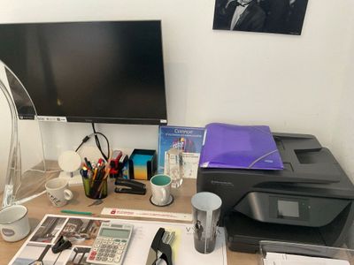un bureau sur lequel se trouvent un ordinateur, une imprimante et d'autres fournitures de bureau