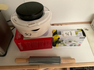 un rouleau à pâtisserie posé sur une table, à côté d'un récipient contenant de la nourriture