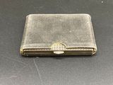 an old silver cigarette case sitting on top of a black table