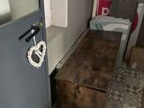 un petit lit dans un coin d'une pièce dont la porte est bleue