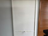 une porte blanche dans un coin d'une pièce au sol en parquet