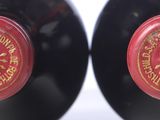 two bottles of red wine with a clock on the top