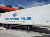 the truck is parked in front of a building with a blue sky in the background
