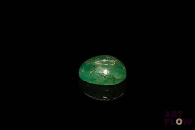a close up of a green stone on a black surface