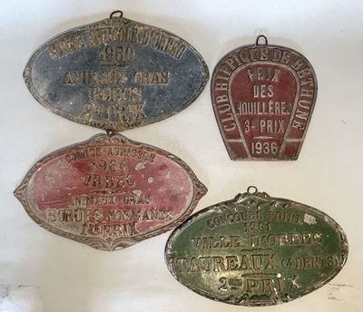 three old metal signs are hanging on a wall in a room