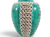 a green vase with a decorative design on it