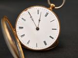 une montre de poche en or avec des chiffres romains