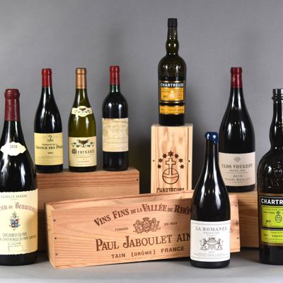 Plusieurs bouteilles de vin sont alignées les unes à côté des autres près d'une caisse en bois