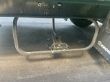underside view of a green truck with a flat bed and a flat tire