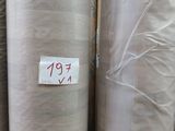 Plusieurs rouleaux de tissu sont empilés les uns sur les autres dans un entrepôt