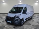 la camionnette blanche est garée dans une grande pièce au sol en damier