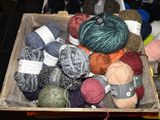 many balls of yarn in a wooden box on a table