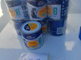 many cans of paint sitting on a table with a price tag