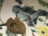 a plate with a bird and a hedge on it