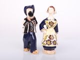 two figurines of a man and a woman standing next to each other
