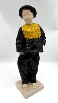 figurine représentant un garçon vêtu d'un costume noir et d'un col jaune