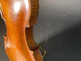an old violin sitting on top of a table next to a black background