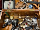 une boîte en bois remplie d'une sélection de montres et d'autres objets