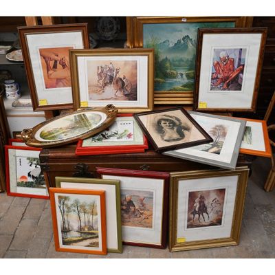 de nombreux tableaux encadrés posés sur une table sur laquelle se trouvent des photos